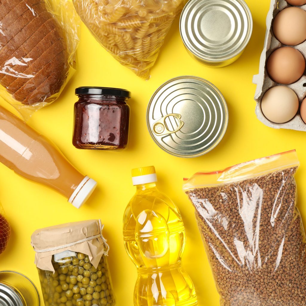 Different food on yellow background, top view. Donation concept